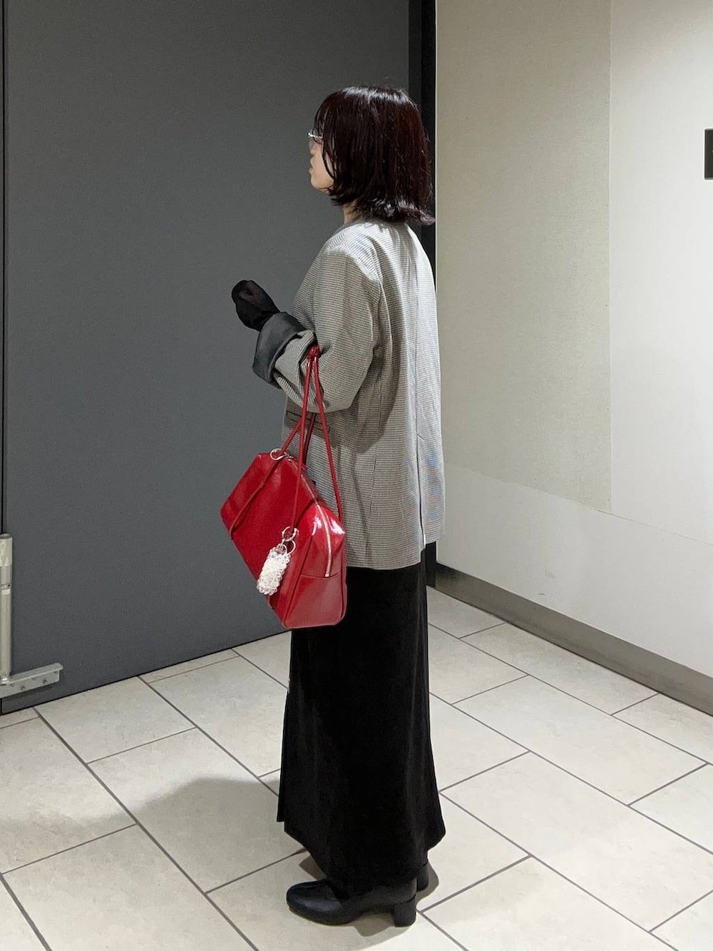 その他のテーラードジャケット、ブラック系のスカート、レッド系のボストンバッグを着用したレディースの秋コーディネートの2枚目の写真