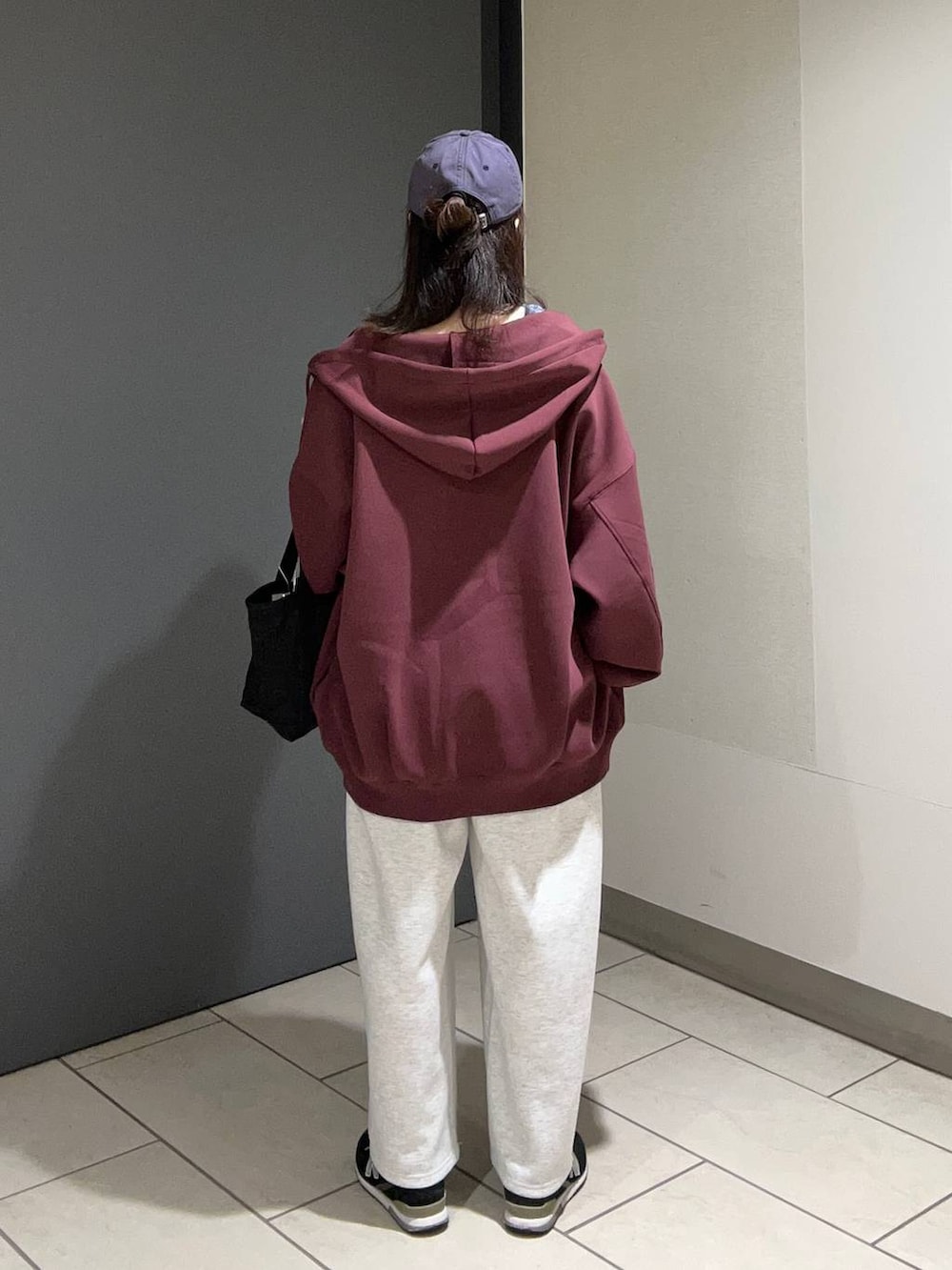 グレー系のスウェットパンツ、ブラック系のショルダーバッグ、レッド系のパーカーを着用したレディースの秋コーディネートの3枚目の写真