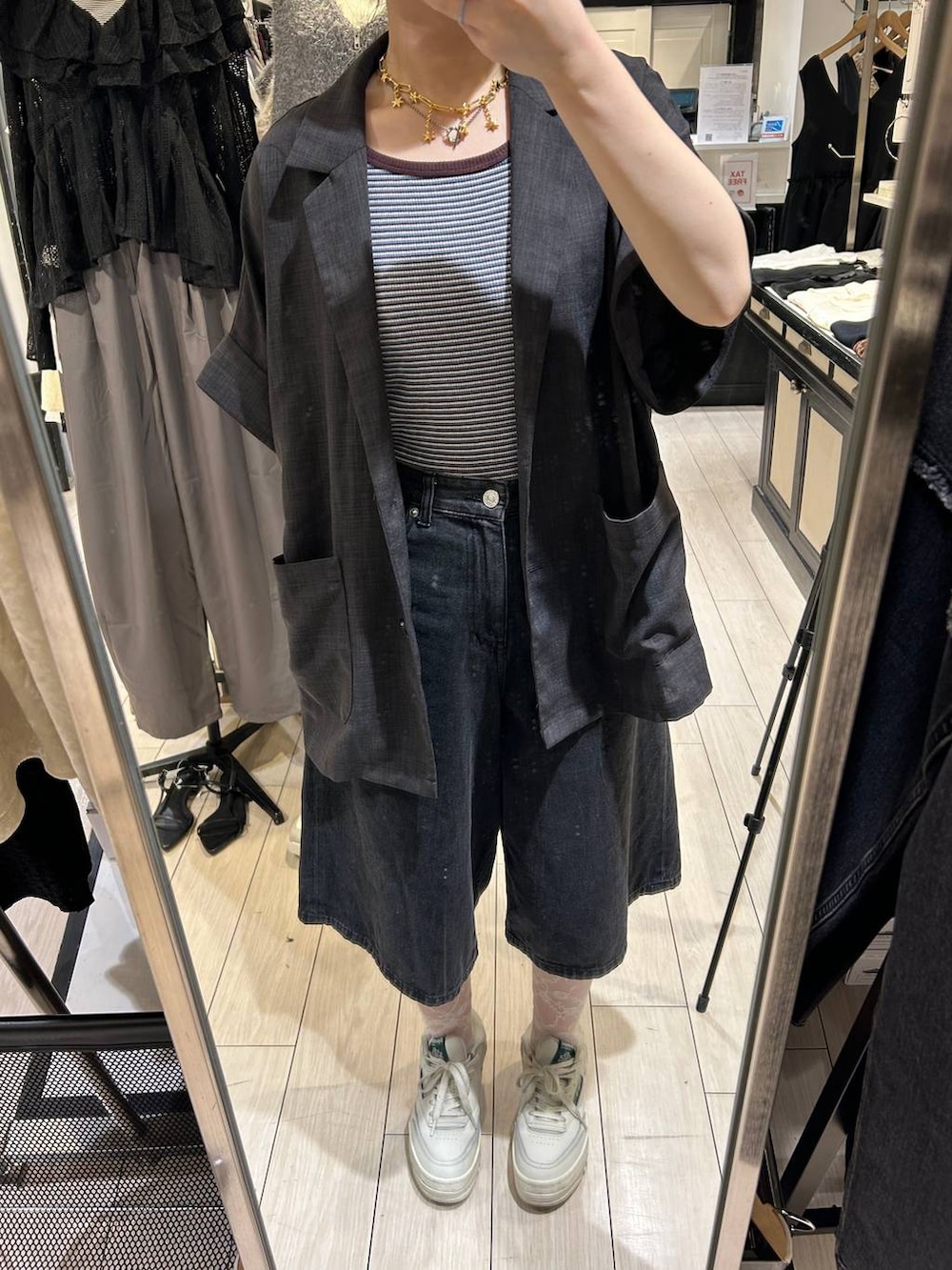 ブルー系のタンクトップ、ブラック系のデニムパンツ、グレー系のテーラードジャケットを着用したレディースの夏コーディネートの4枚目の写真