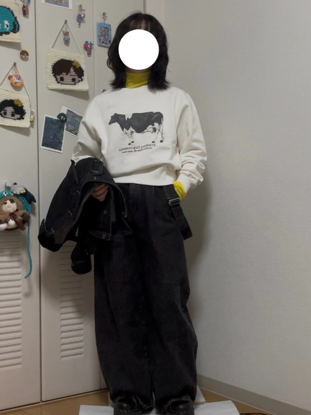 ホワイト系のスウェット、ブラック系のデニムジャケット、ベージュ系のショルダーバッグを着用したレディースの冬コーディネートの2枚目の写真
