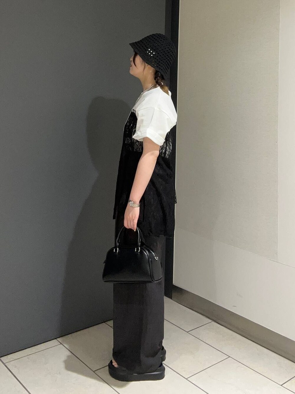 ブラウン系のサンダル、ホワイト系のTシャツ/カットソー、グレー系のスラックスを着用したレディースの春コーディネートの2枚目の写真