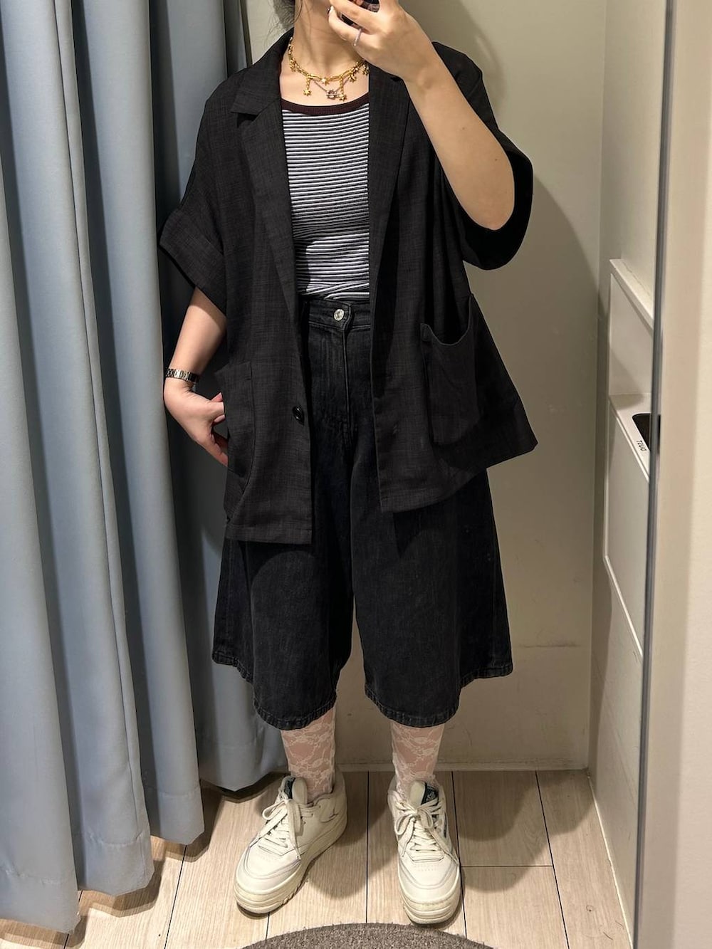 ブルー系のタンクトップ、ブラック系のデニムパンツ、グレー系のテーラードジャケットを着用したレディースの夏コーディネートの2枚目の写真