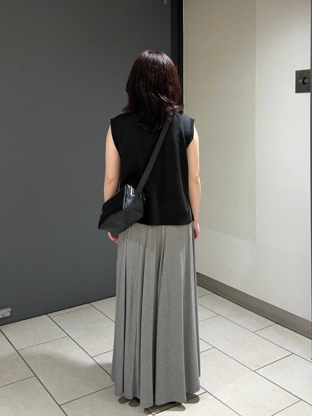 ブラック系のキャミソール、ブラック系のサンダル、グレー系のスカートを着用したレディースの夏コーディネートの3枚目の写真