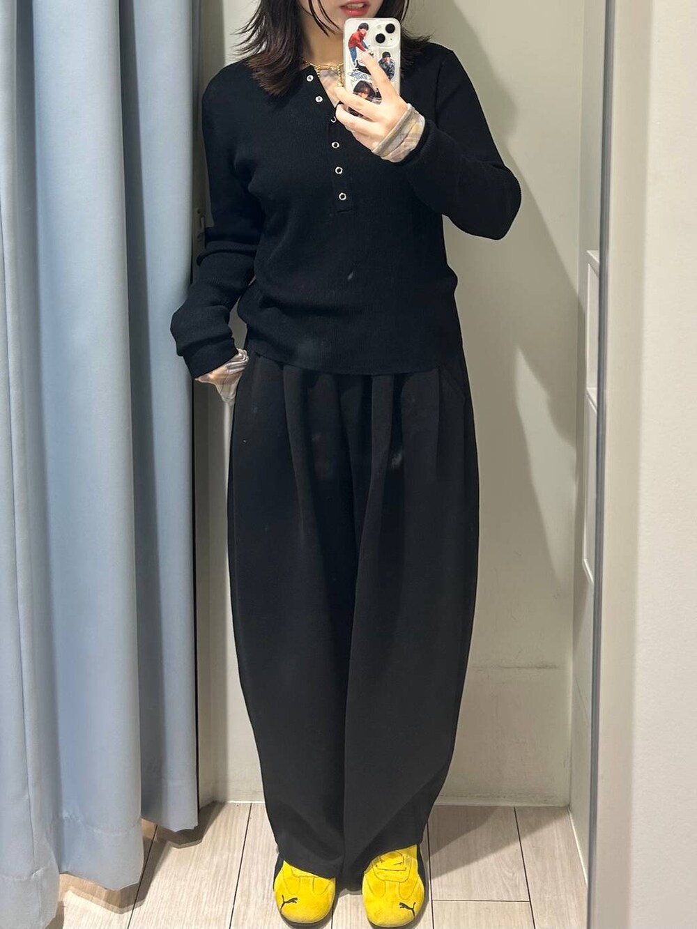 ブラック系のスウェットパンツ、ブラック系のニット/セーター、イエロー系のTシャツ/カットソーを着用したレディースの秋コーディネートの2枚目の写真