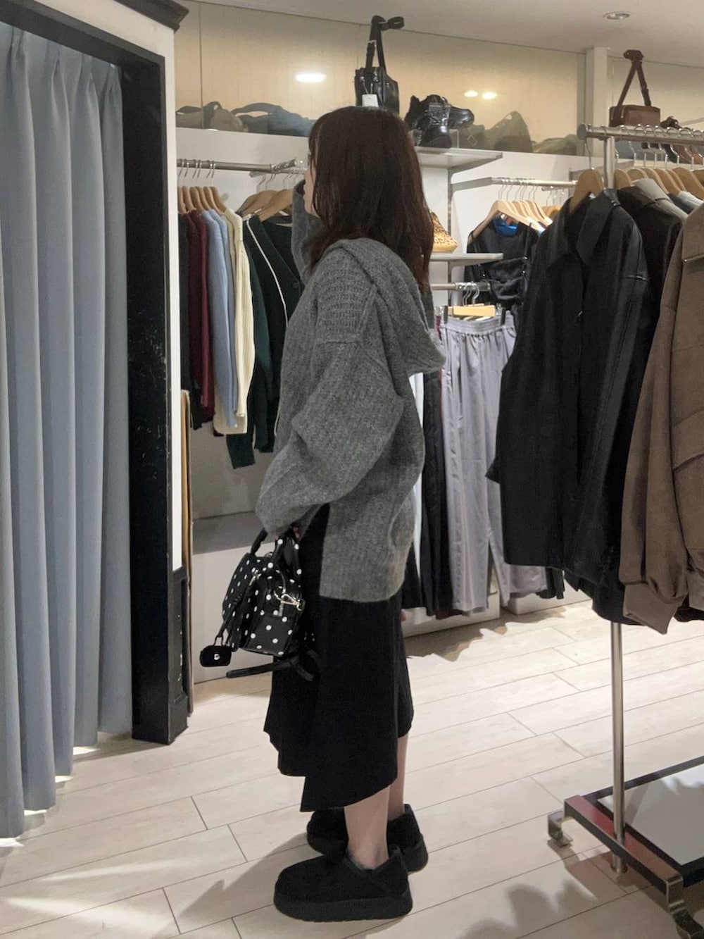 ブラック系のチノパンツ、グレー系のニット/セーター、ブラック系のその他シューズを着用したレディースの秋コーディネートの2枚目の写真