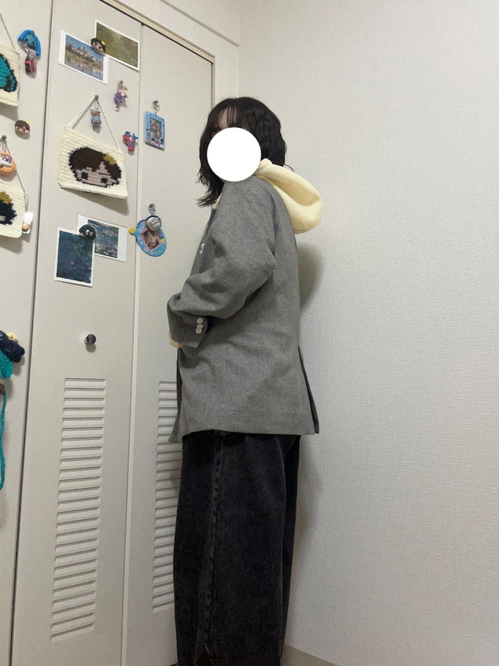 イエロー系のスニーカー、ブラック系のデニムパンツ、ブラック系のハンドバッグを着用したレディースの冬コーディネートの3枚目の写真