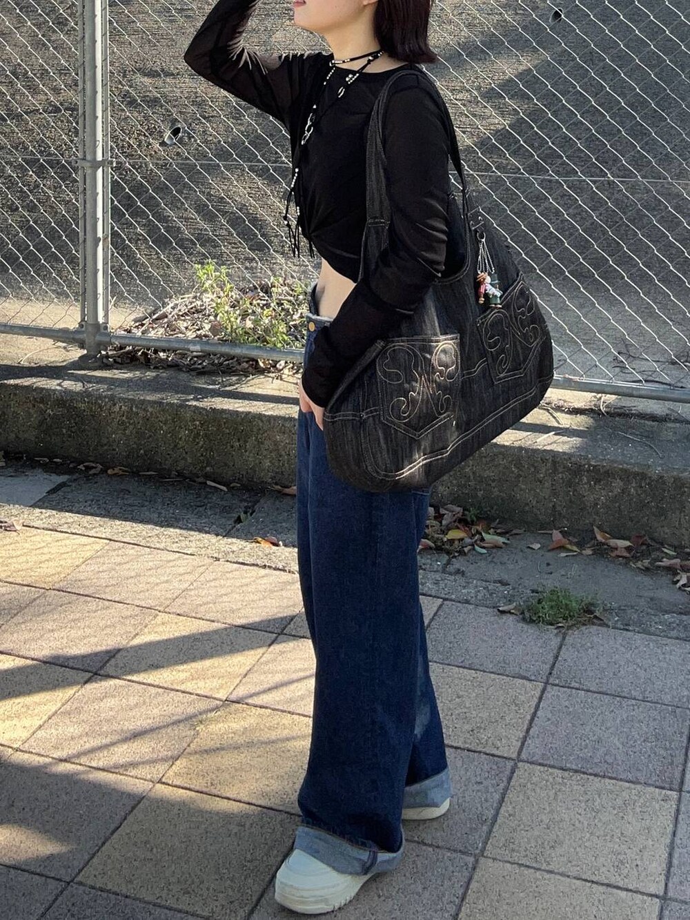 ブラック系のTシャツ/カットソー、ブラック系のネックレスを着用したレディースの秋コーディネートの2枚目の写真