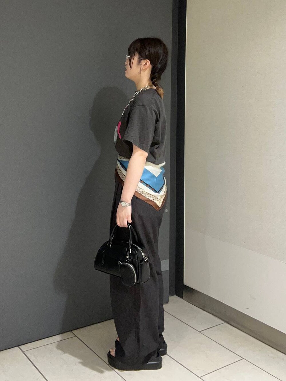 ブラウン系のサンダル、グレー系のTシャツ/カットソー、グレー系のスラックスを着用したレディースの春コーディネートの2枚目の写真