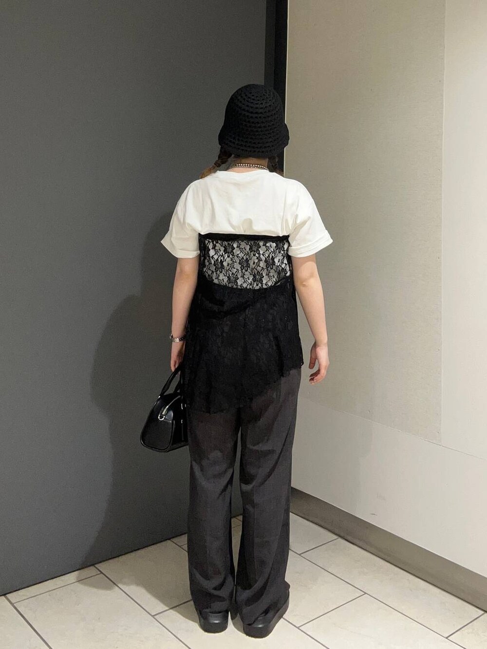 ブラウン系のサンダル、ホワイト系のTシャツ/カットソー、グレー系のスラックスを着用したレディースの春コーディネートの3枚目の写真