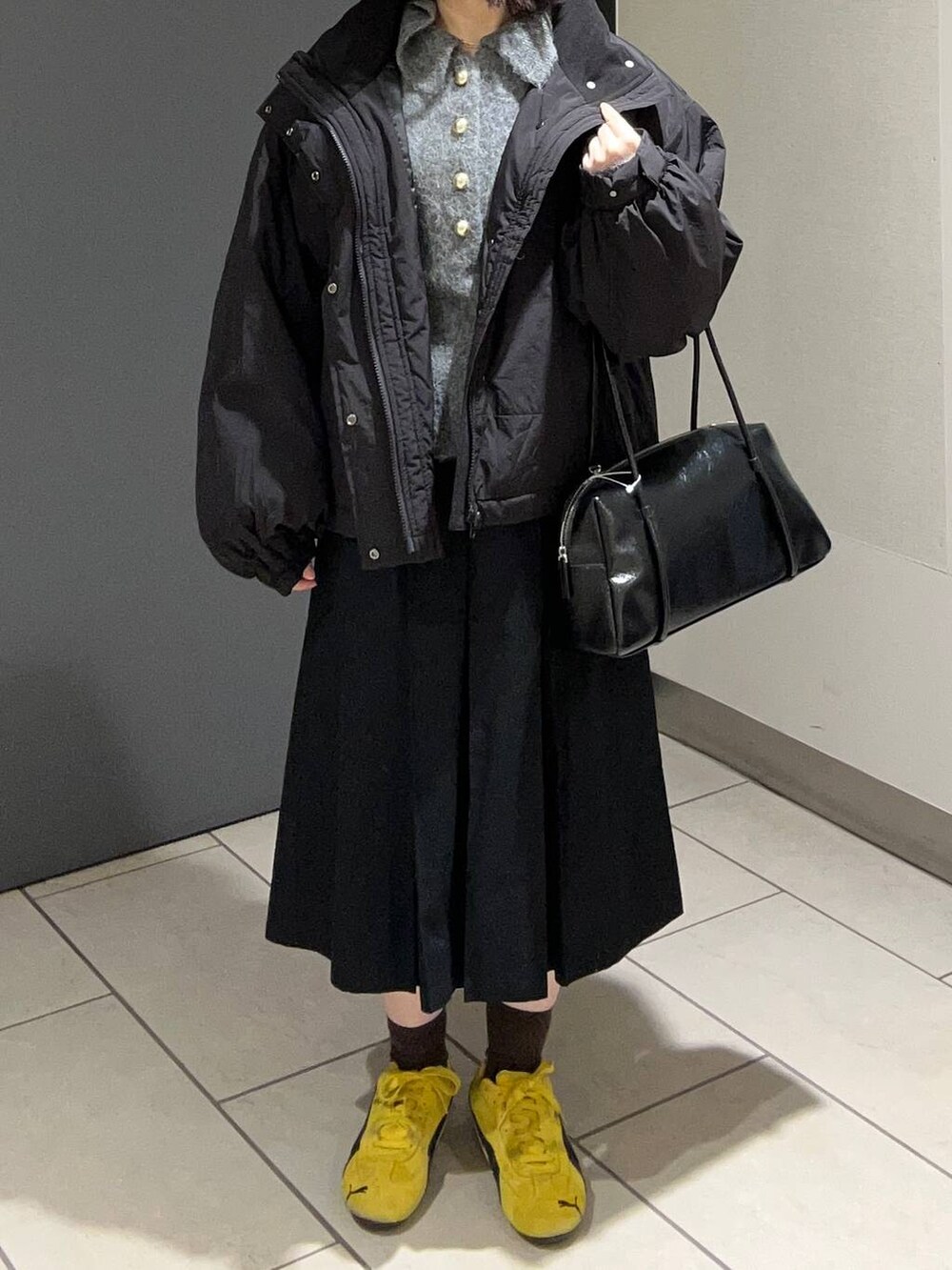 ブラック系のその他アウター、ブラック系のチノパンツ、ブラック系のボストンバッグを着用したレディースの秋コーディネートの4枚目の写真