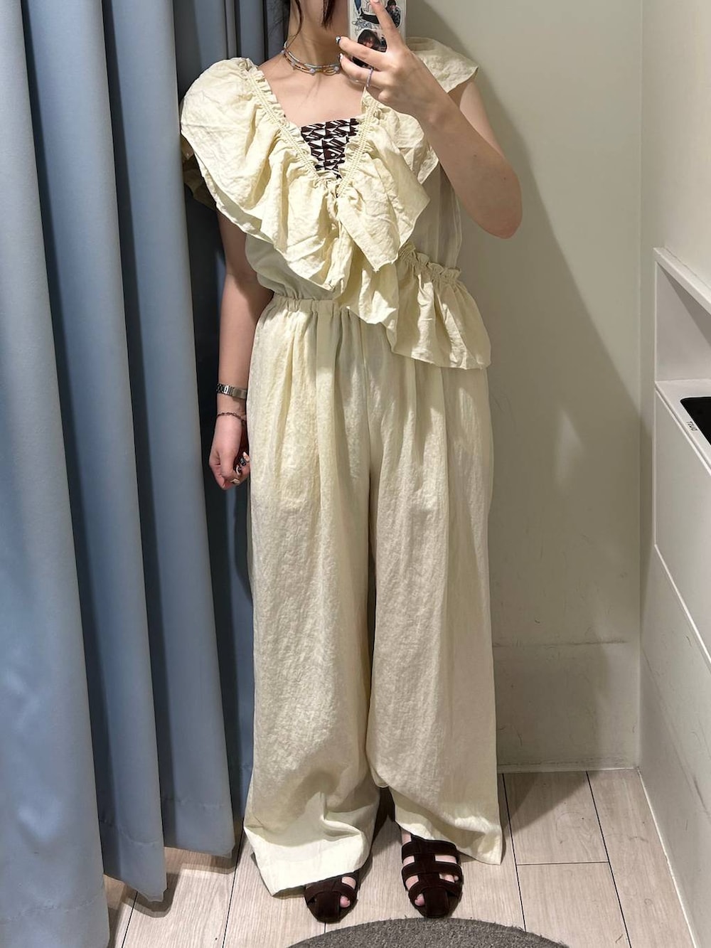 ブラウン系のサンダル、ホワイト系のサロペット/オーバーオール、ブラウン系のネックレスを着用したレディースの夏コーディネートの2枚目の写真