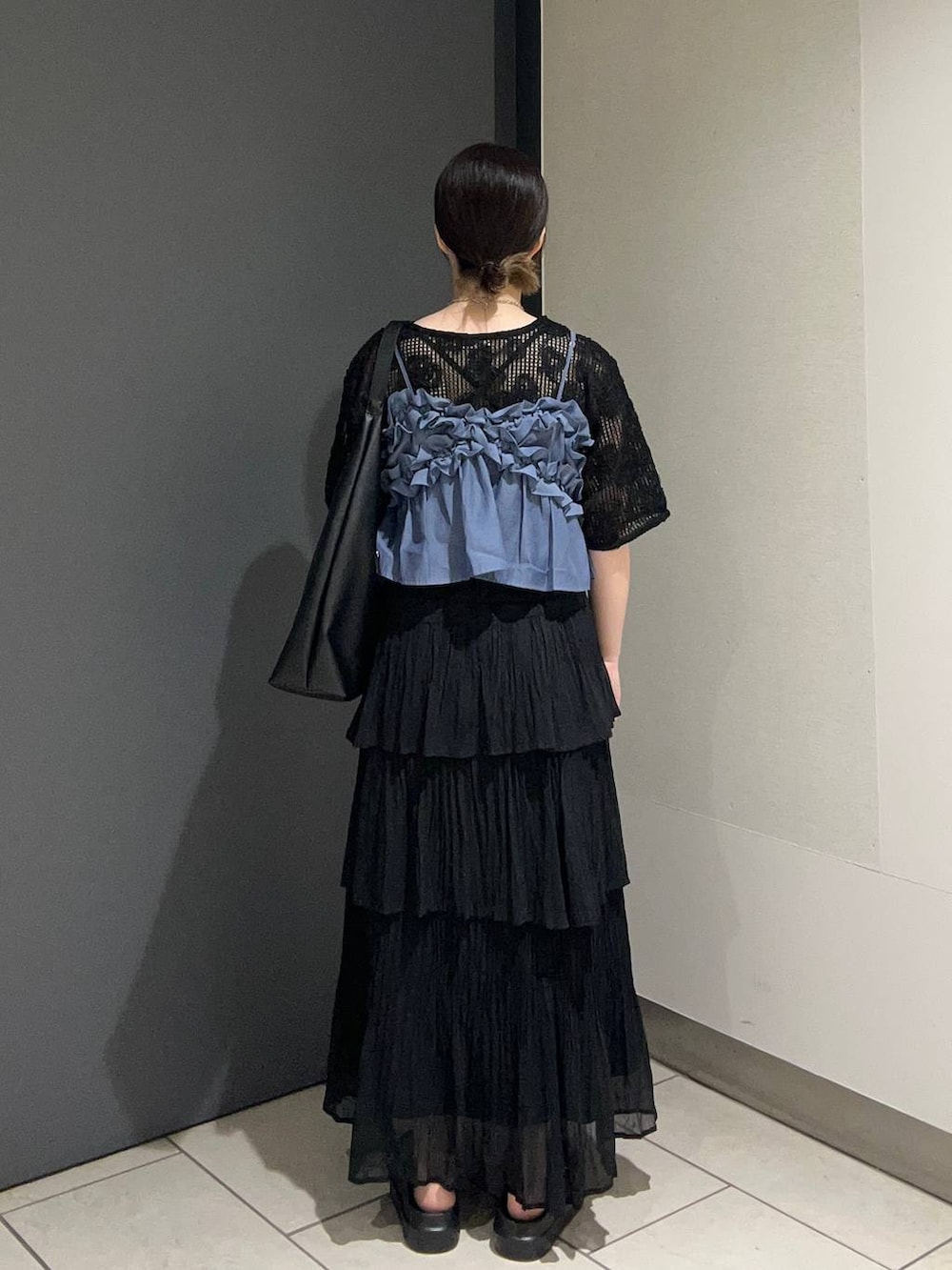 ブラック系のショルダーバッグ、ブルー系のキャミソール、ブラック系のサンダルを着用したレディースの春コーディネートの3枚目の写真