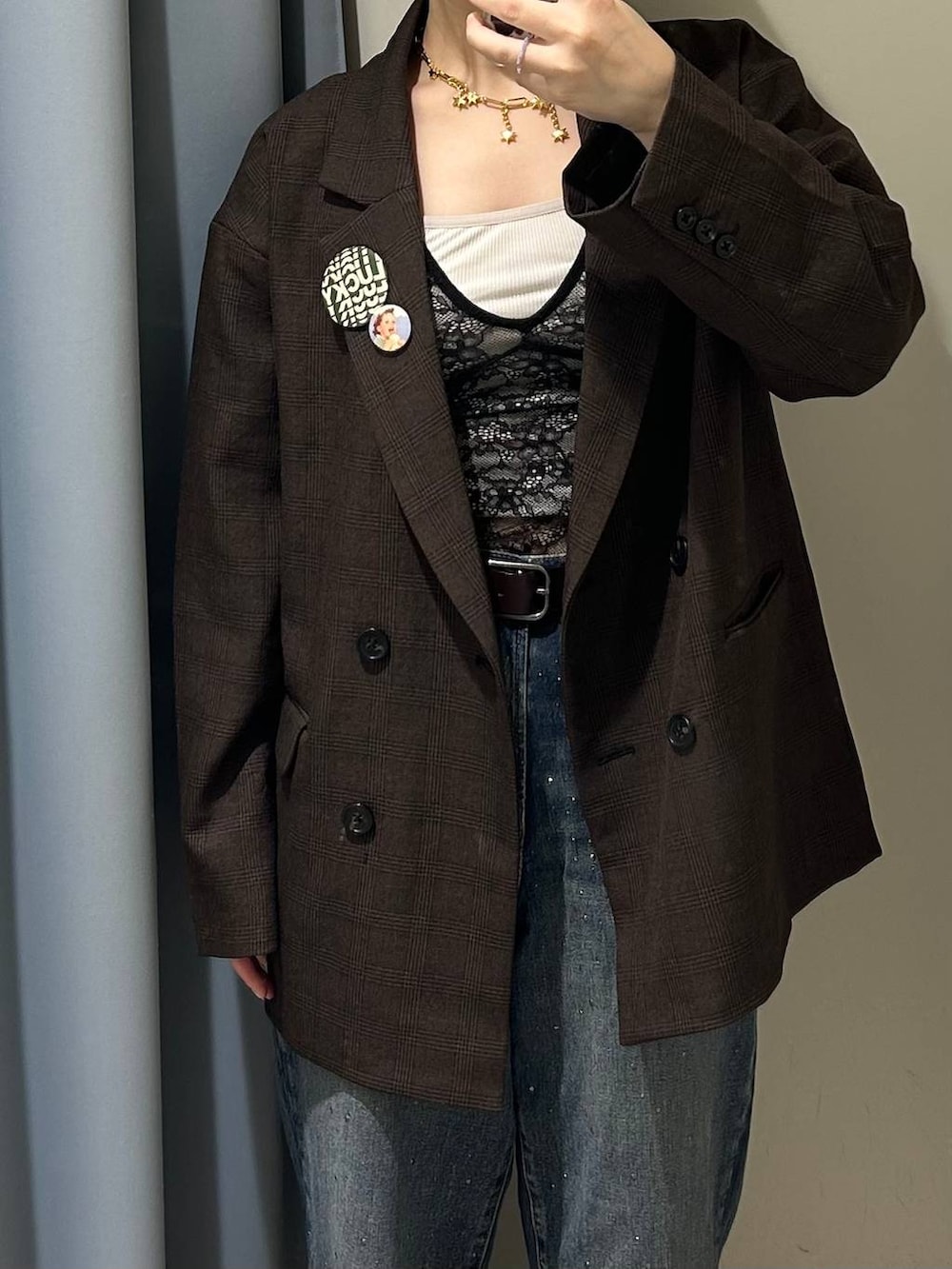 ブルー系のデニムパンツ、ブラウン系のテーラードジャケット、ブラウン系のサンダルを着用したレディースの秋コーディネートの2枚目の写真