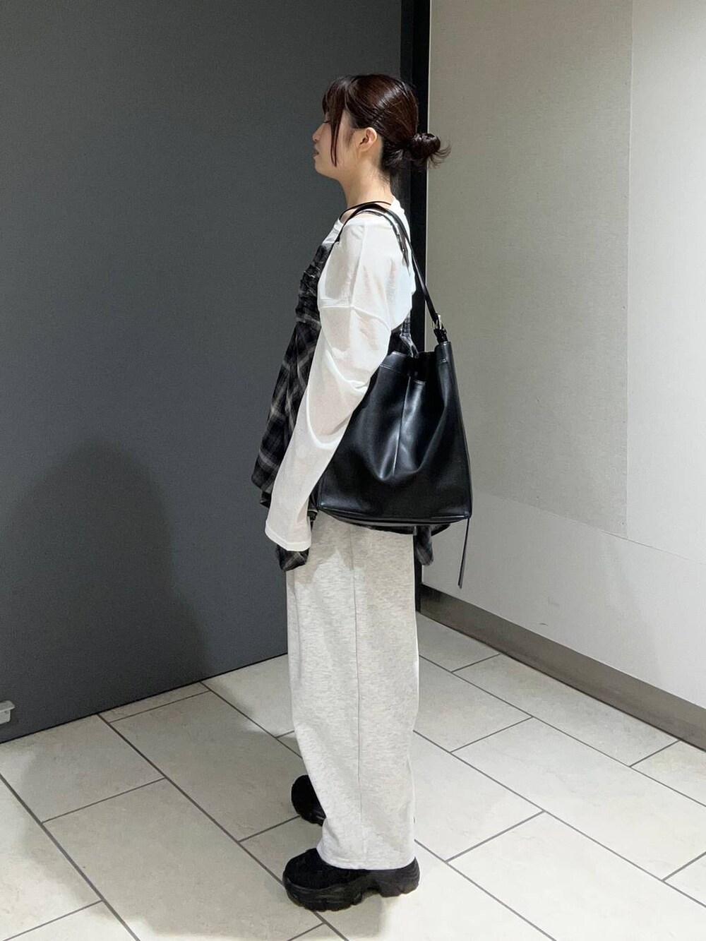 ブラック系のキャミソール、グレー系のスウェットパンツ、ブラック系のスニーカーを着用したレディースの夏コーディネートの2枚目の写真
