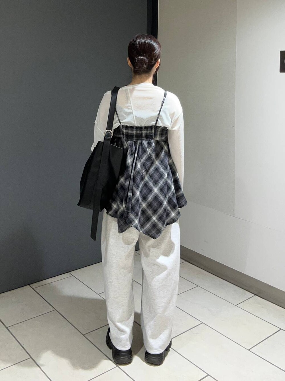 ブラック系のキャミソール、グレー系のスウェットパンツ、ブラック系のスニーカーを着用したレディースの夏コーディネートの3枚目の写真