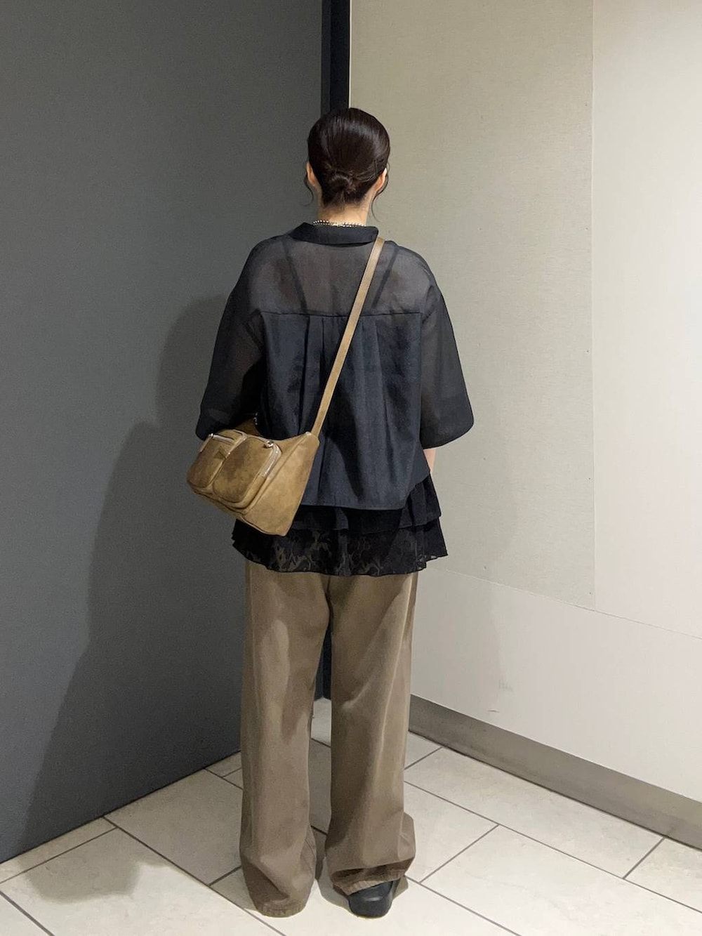 ブラウン系のサンダル、ブラック系のシャツ/ブラウス、ブラウン系のデニムパンツを着用したレディースの夏コーディネートの3枚目の写真