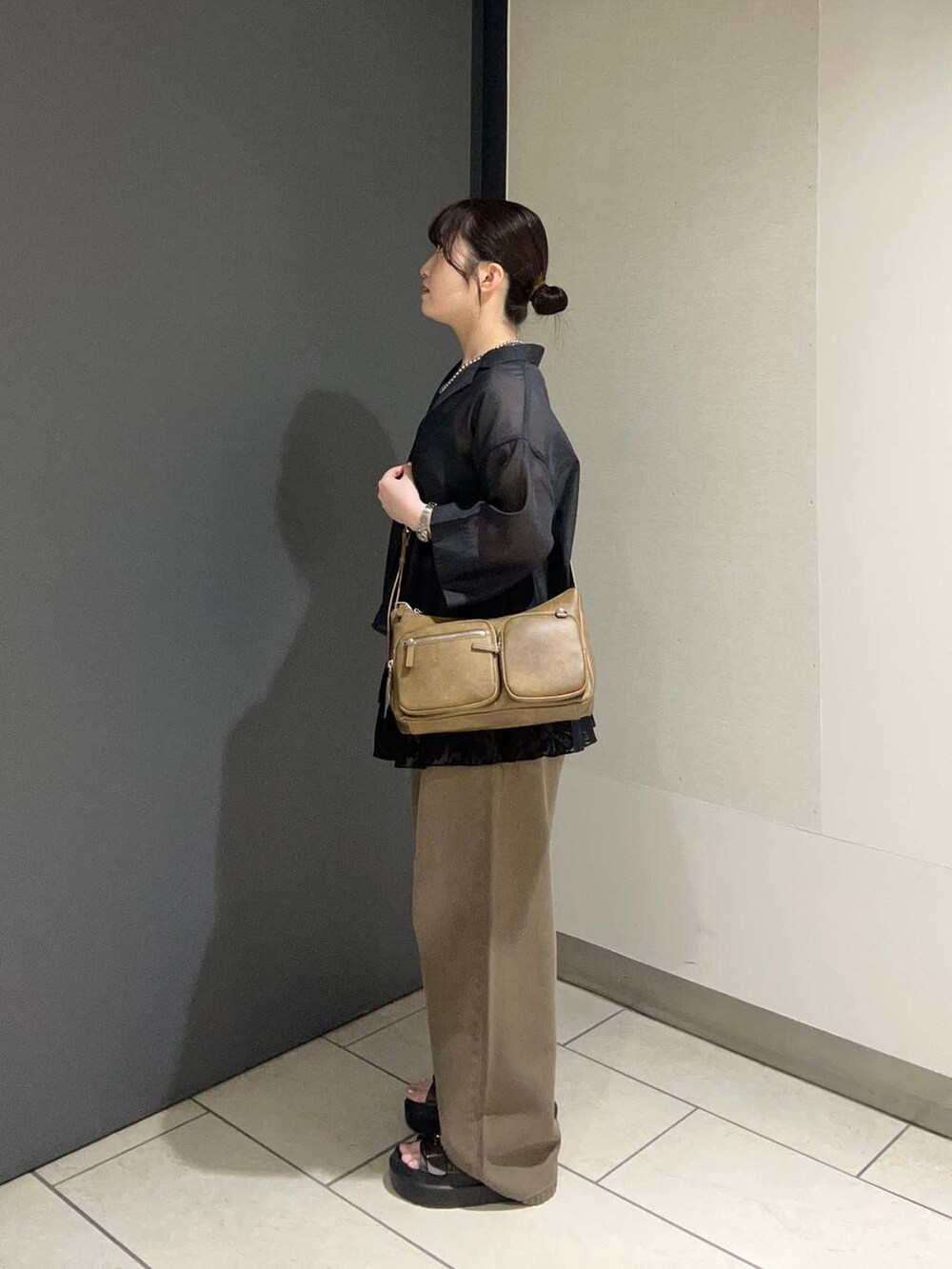 ブラウン系のサンダル、ブラック系のシャツ/ブラウス、ブラウン系のデニムパンツを着用したレディースの夏コーディネートの2枚目の写真