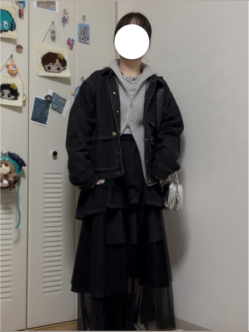 ブラック系のデニムジャケット、グレー系のトップス、シルバー系のTシャツ/カットソーを着用したレディースの冬コーディネートの3枚目の写真