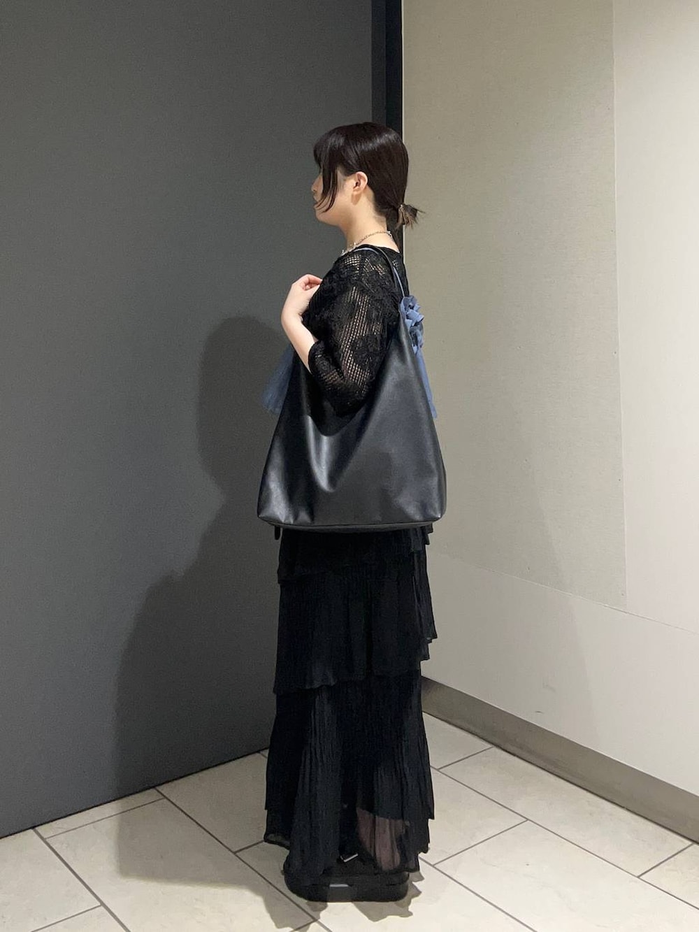 ブラック系のショルダーバッグ、ブルー系のキャミソール、ブラック系のサンダルを着用したレディースの春コーディネートの2枚目の写真