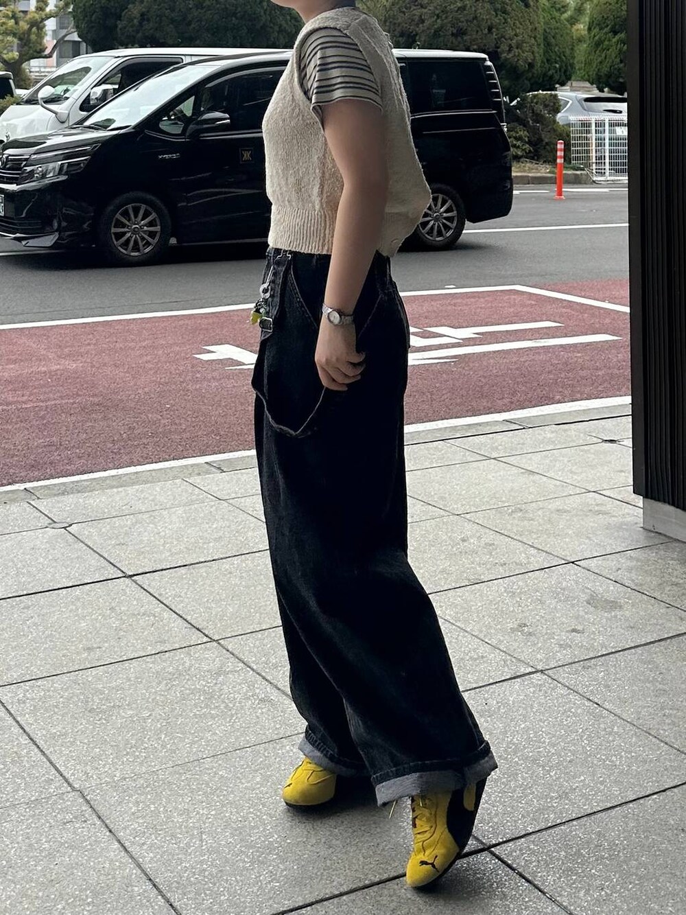 ホワイト系のTシャツ/カットソー、ブラック系のデニムパンツ、ベージュ系のニット/セーターを着用したレディースの春コーディネートの3枚目の写真