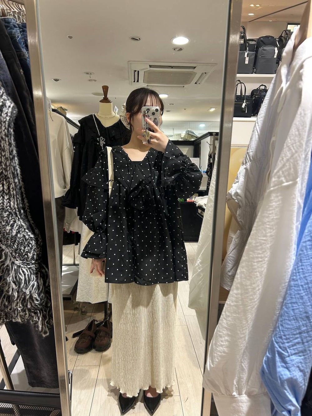 ホワイト系のショルダーバッグ、ブラック系のパンプス、ホワイト系のスカートを着用したレディースの秋コーディネートの4枚目の写真