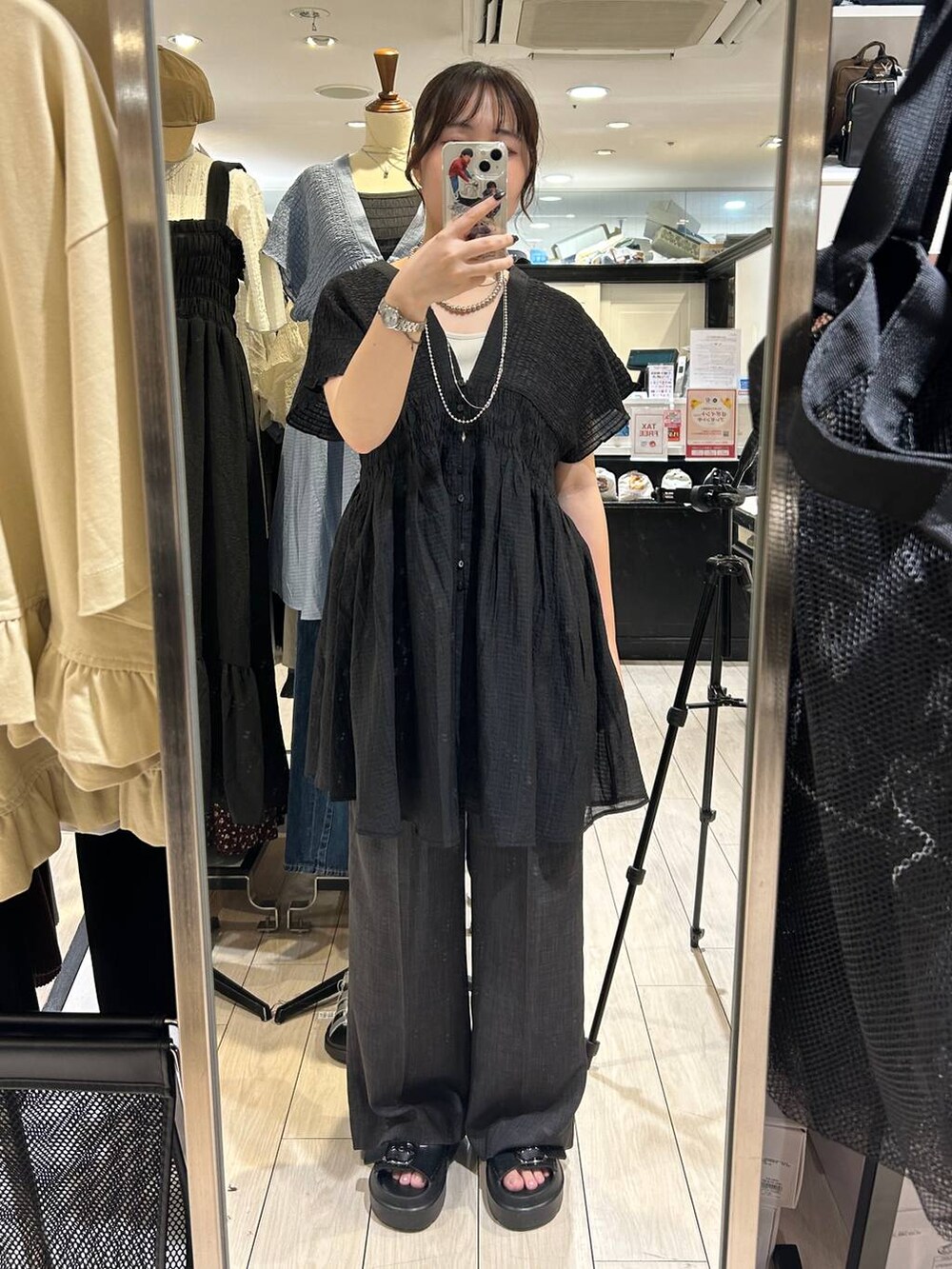 ホワイト系のTシャツ/カットソー、ブラウン系のサンダル、グレー系のスラックスを着用したレディースの夏コーディネートの3枚目の写真