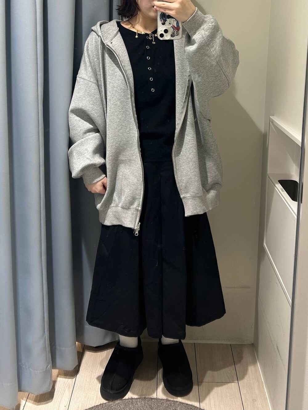 グレー系のパーカー、ブラック系のチノパンツ、ブラック系のニット/セーターを着用したレディースの秋コーディネートの2枚目の写真