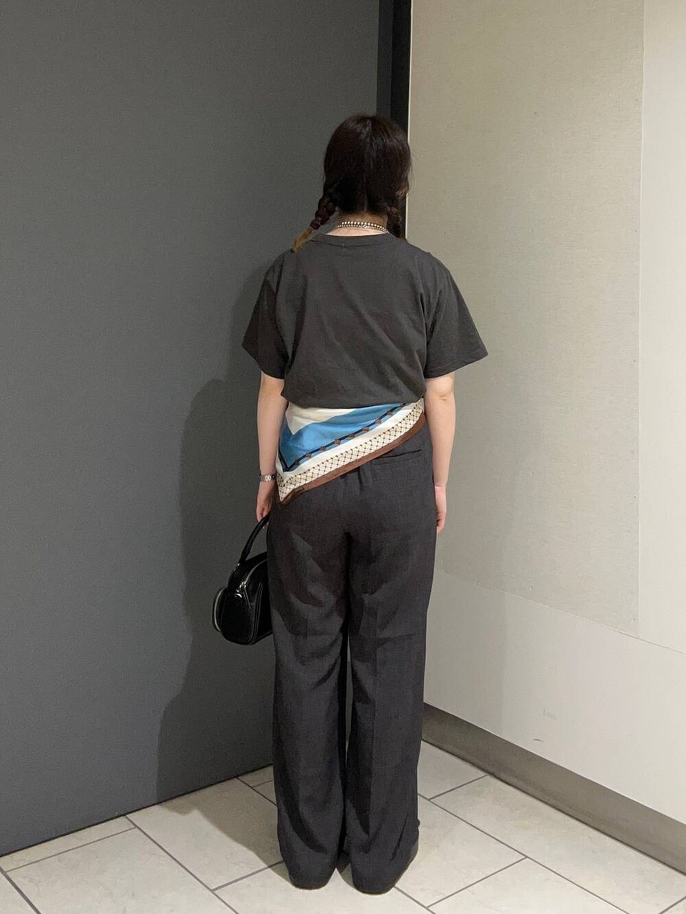 ブラウン系のサンダル、グレー系のTシャツ/カットソー、グレー系のスラックスを着用したレディースの春コーディネートの3枚目の写真