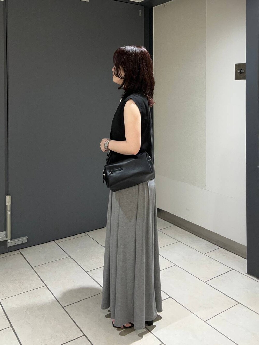 ブラック系のキャミソール、ブラック系のサンダル、グレー系のスカートを着用したレディースの夏コーディネートの2枚目の写真