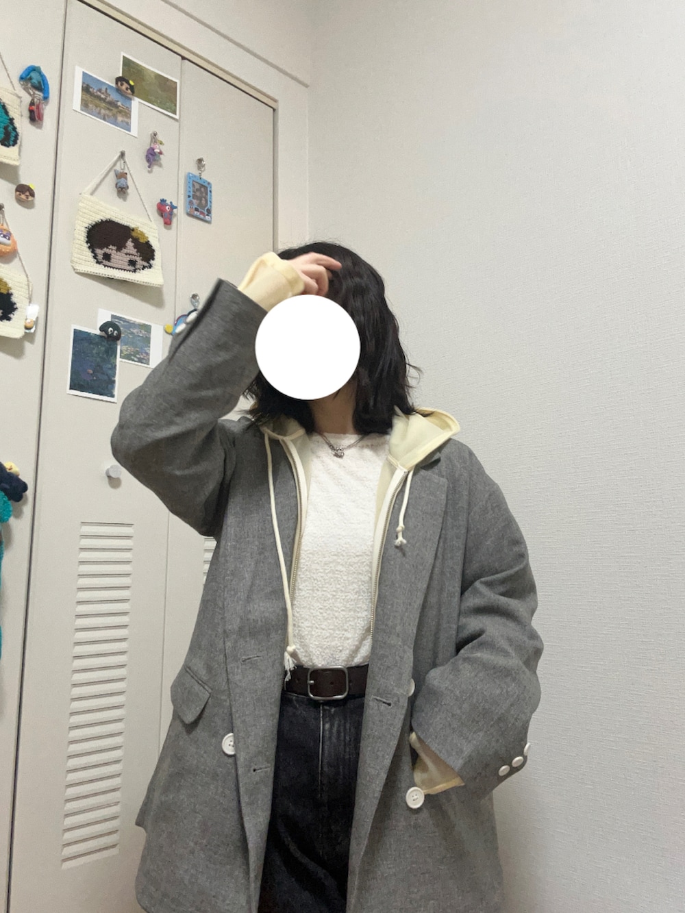 イエロー系のスニーカー、ブラック系のデニムパンツ、ブラック系のハンドバッグを着用したレディースの冬コーディネートの4枚目の写真