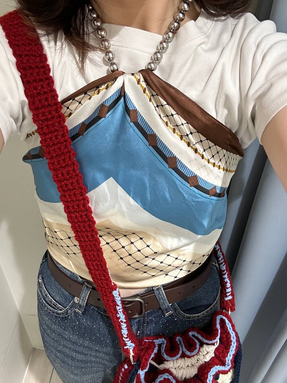 ホワイト系のTシャツ/カットソー、ブルー系のデニムパンツ、ブラウン系のサンダルを着用したレディースの夏コーディネートの3枚目の写真