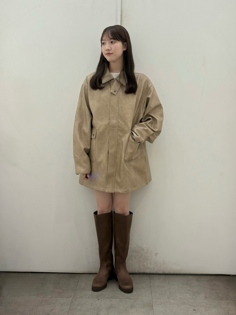 ホワイト系のTシャツ/カットソー、ベージュ系のその他アウター、ブラウン系のブーツを着用したレディースの秋コーディネートの2枚目の写真