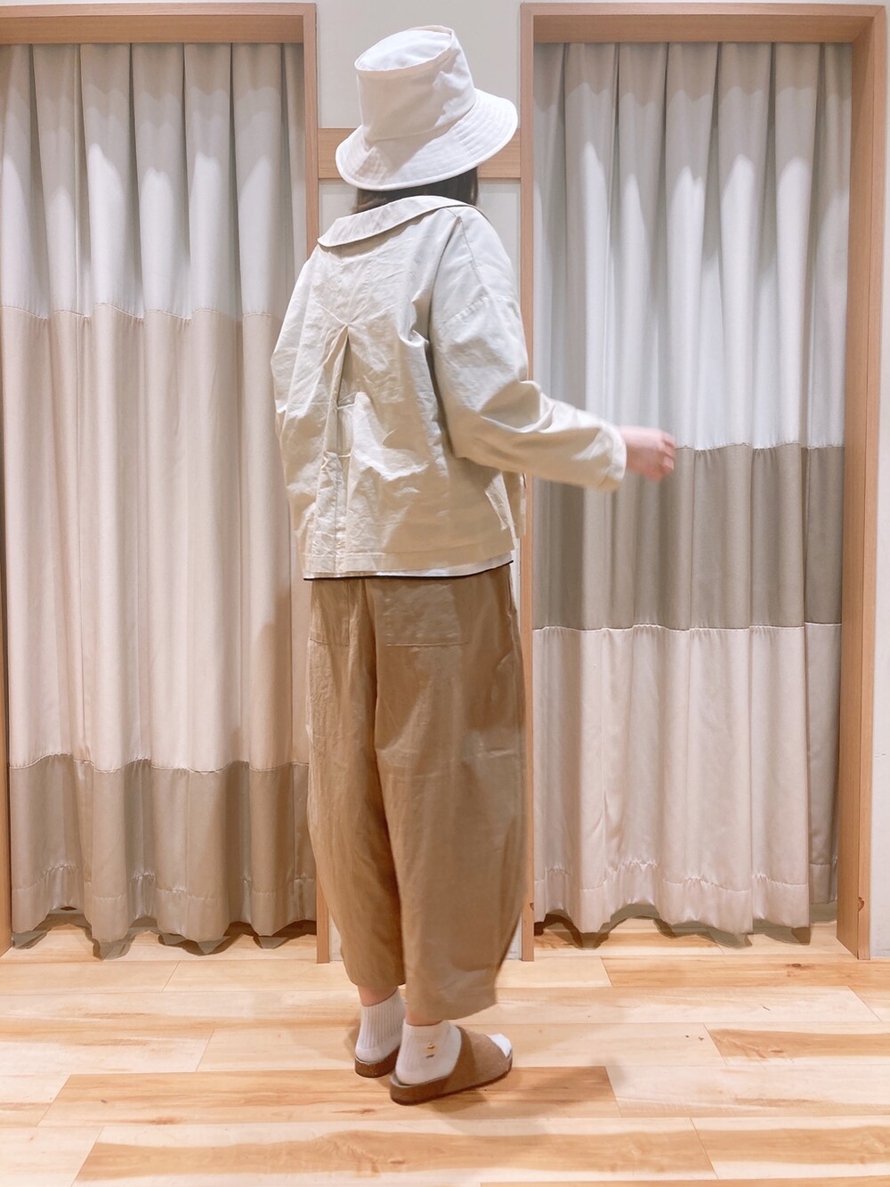 ホワイト系のその他アウター、ブラック系のTシャツ/カットソー、ベージュ系のその他パンツを着用したレディースの春コーディネートの2枚目の写真