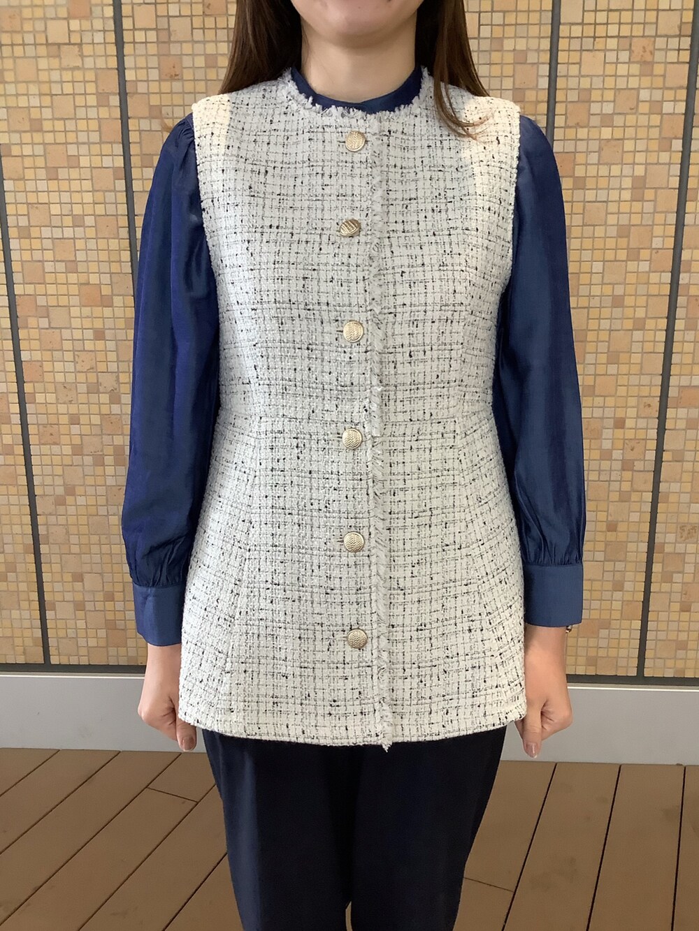 ホワイト系のベスト、ブルー系のシャツ/ブラウスを着用したレディースの秋コーディネートの2枚目の写真