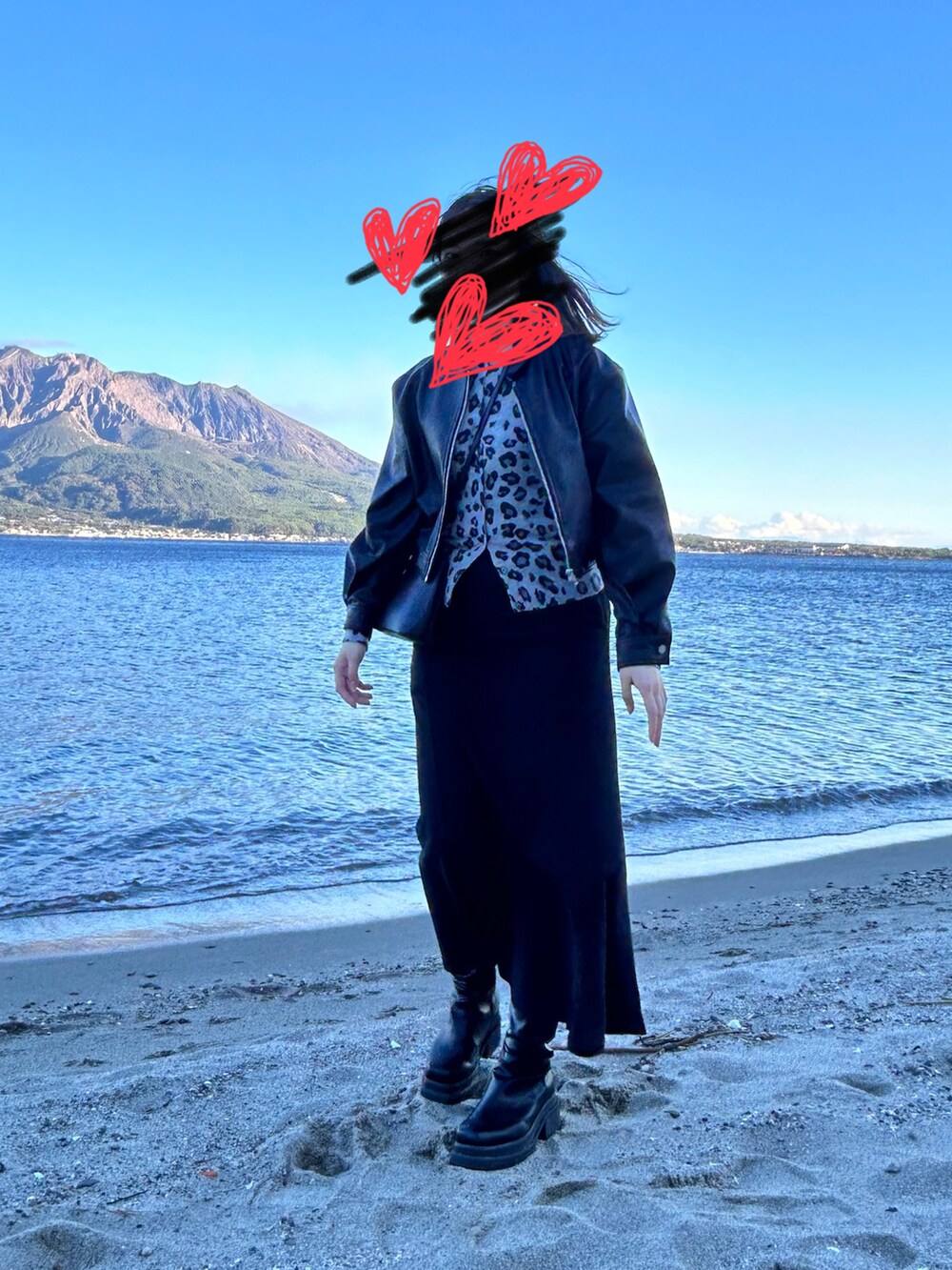 ブラック系のブーツ、ブラック系のスカート、ブラック系のショルダーバッグを着用したレディースの冬コーディネートの2枚目の写真