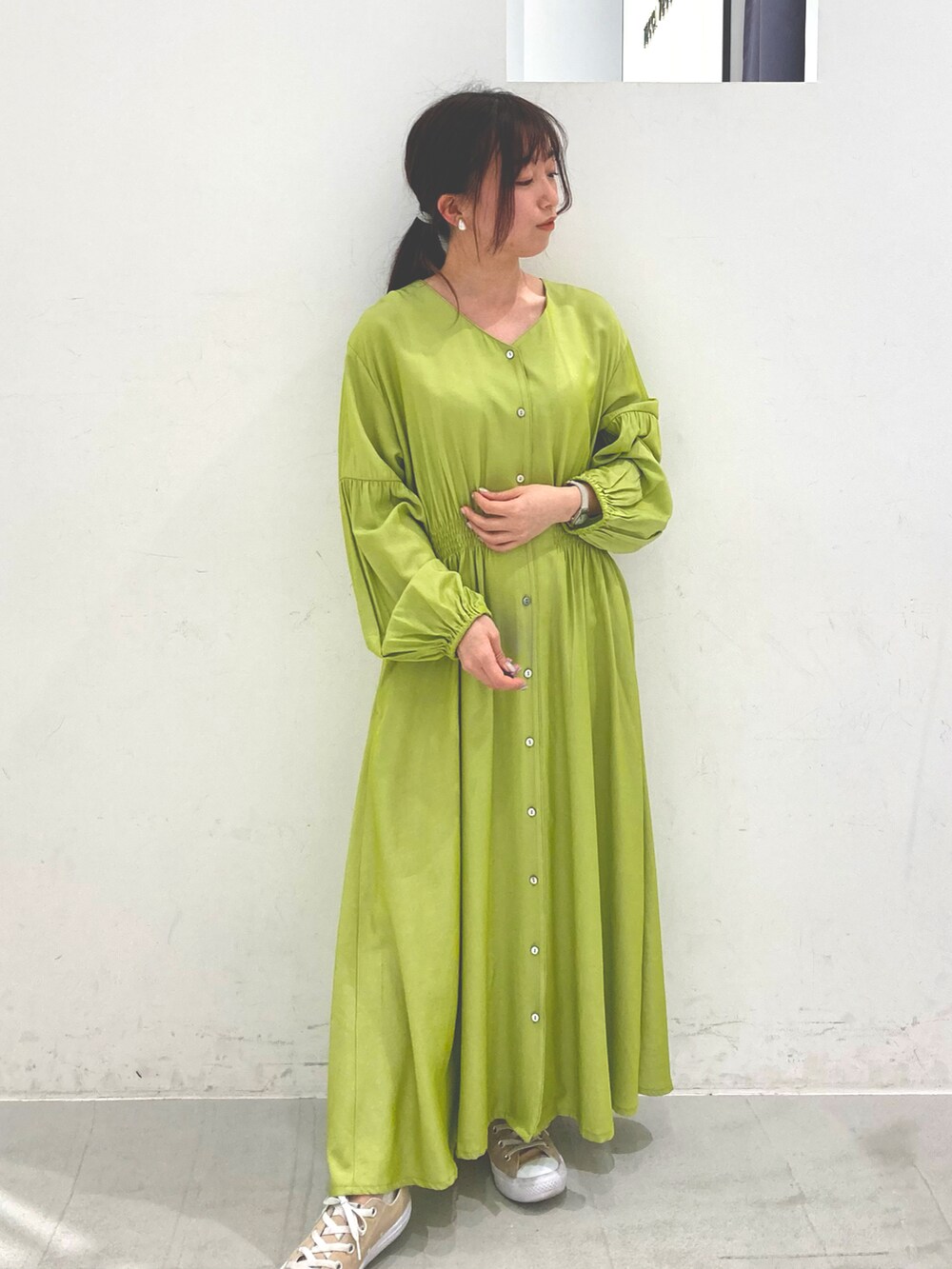 グリーン系のワンピース、ベージュ系のスニーカーを着用したレディースの春コーディネートの2枚目の写真