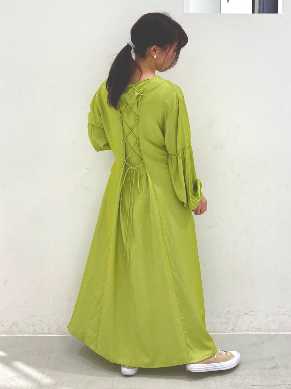 グリーン系のワンピース、ベージュ系のスニーカーを着用したレディースの春コーディネートの3枚目の写真