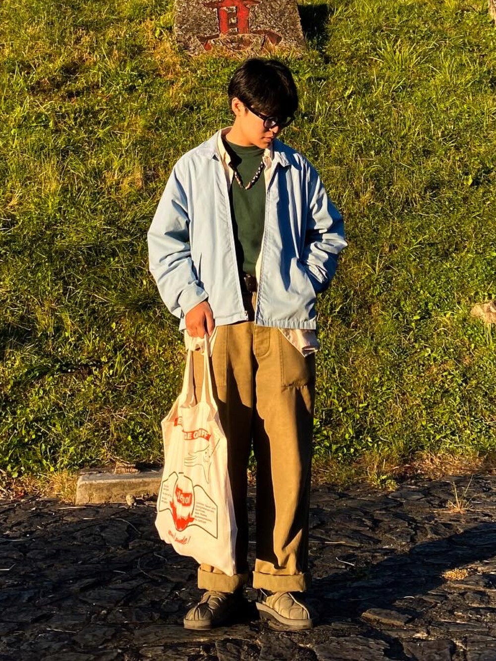 グリーン系のTシャツ/カットソー、ブルー系のジャケット/アウター、グリーン系のサンダルを着用したメンズの秋コーディネートの2枚目の写真