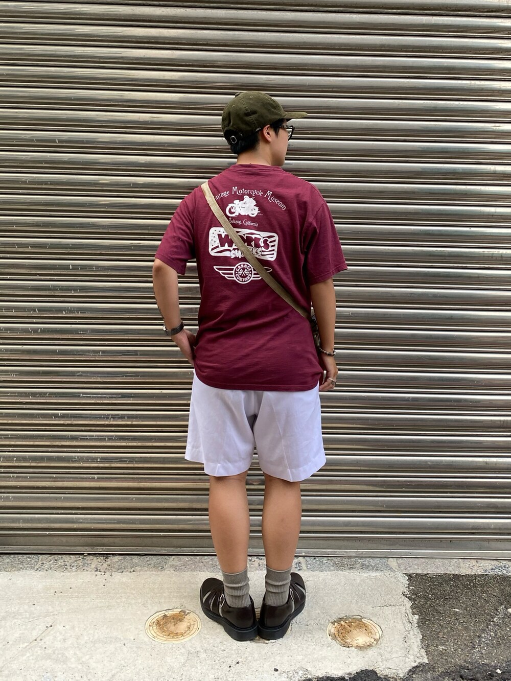 レッド系のTシャツ/カットソー、ホワイト系のパンツ、ブラウン系のサンダルを着用したメンズの秋コーディネートの3枚目の写真