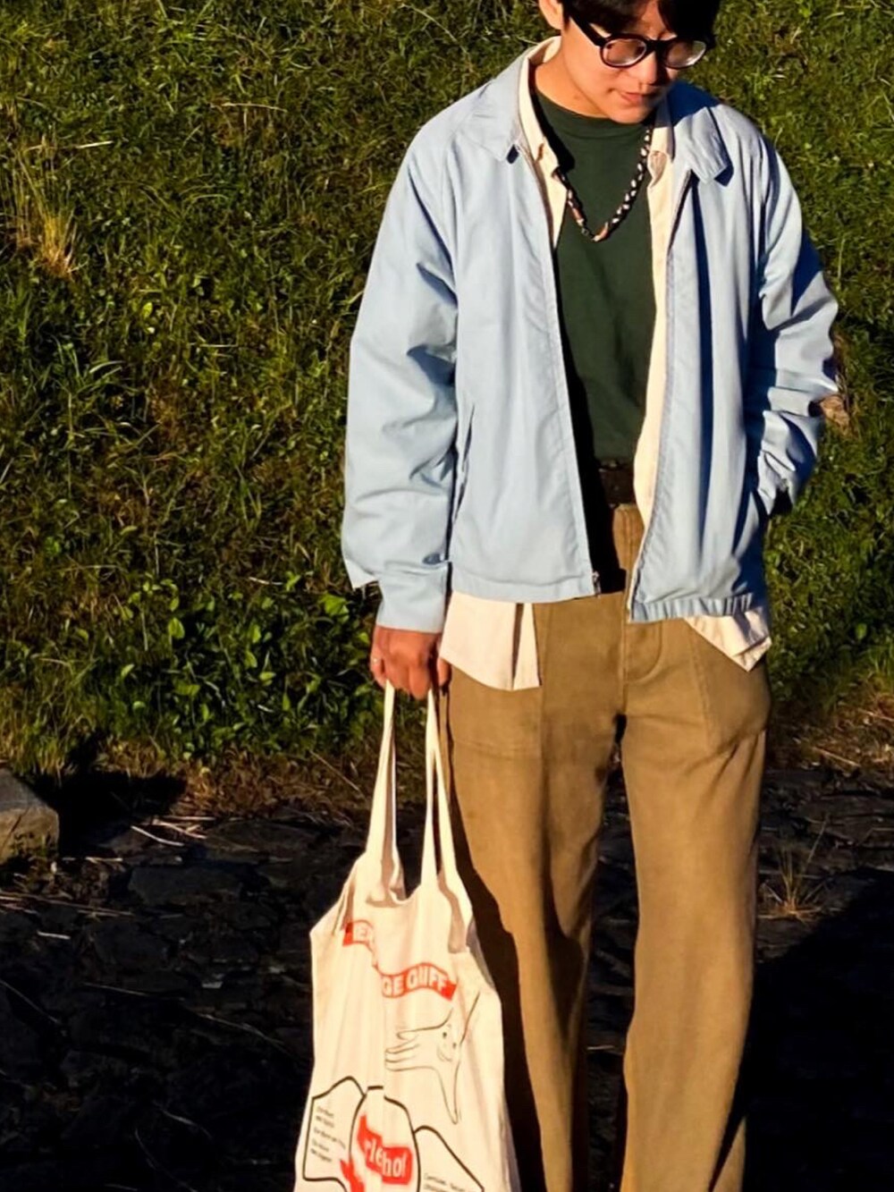 グリーン系のTシャツ/カットソー、ブルー系のジャケット/アウター、グリーン系のサンダルを着用したメンズの秋コーディネートの3枚目の写真