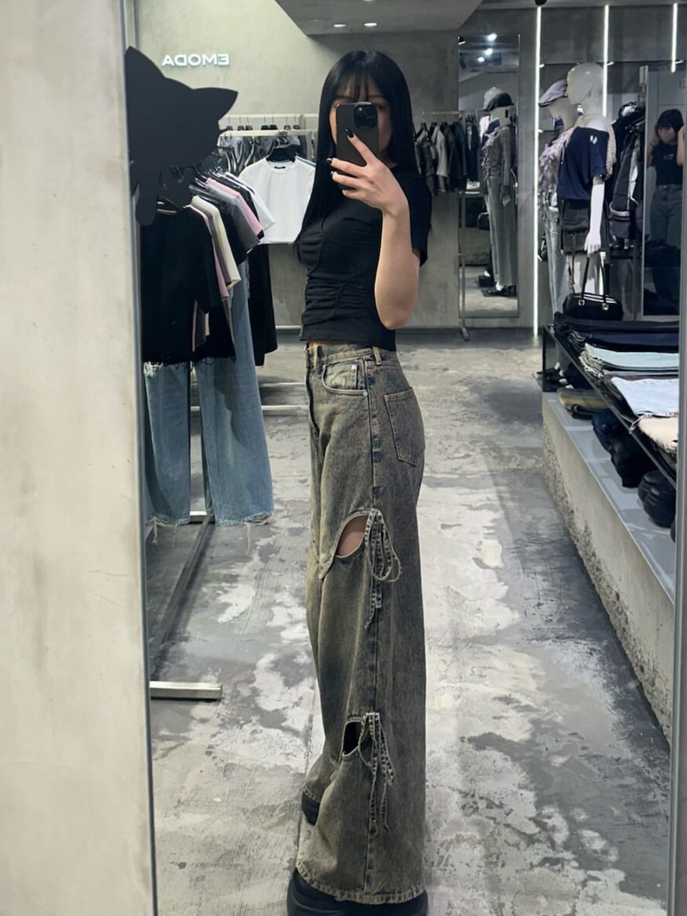 ブラック系のTシャツ/カットソー、ブルー系のデニムパンツを着用したレディースの春コーディネートの2枚目の写真