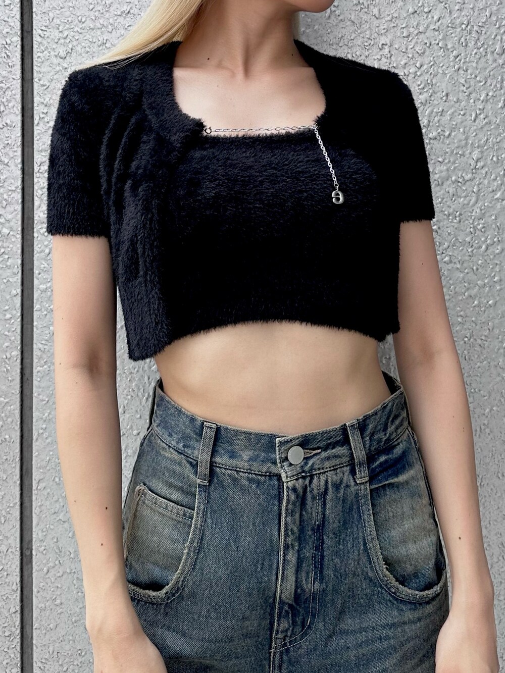 ブラック系のニット/セーター、ブルー系のデニムパンツ、ブラック系のキャップを着用したレディースの夏コーディネートの2枚目の写真