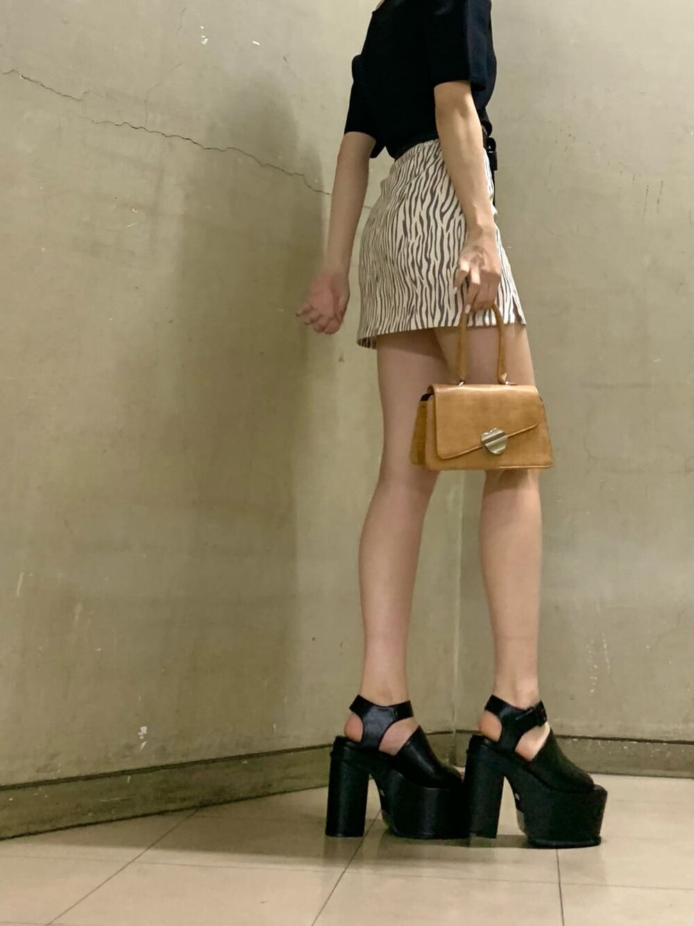 その他のスカート、ブラウン系のハンドバッグ、ブラック系のサンダルを着用したレディースの春コーディネートの2枚目の写真