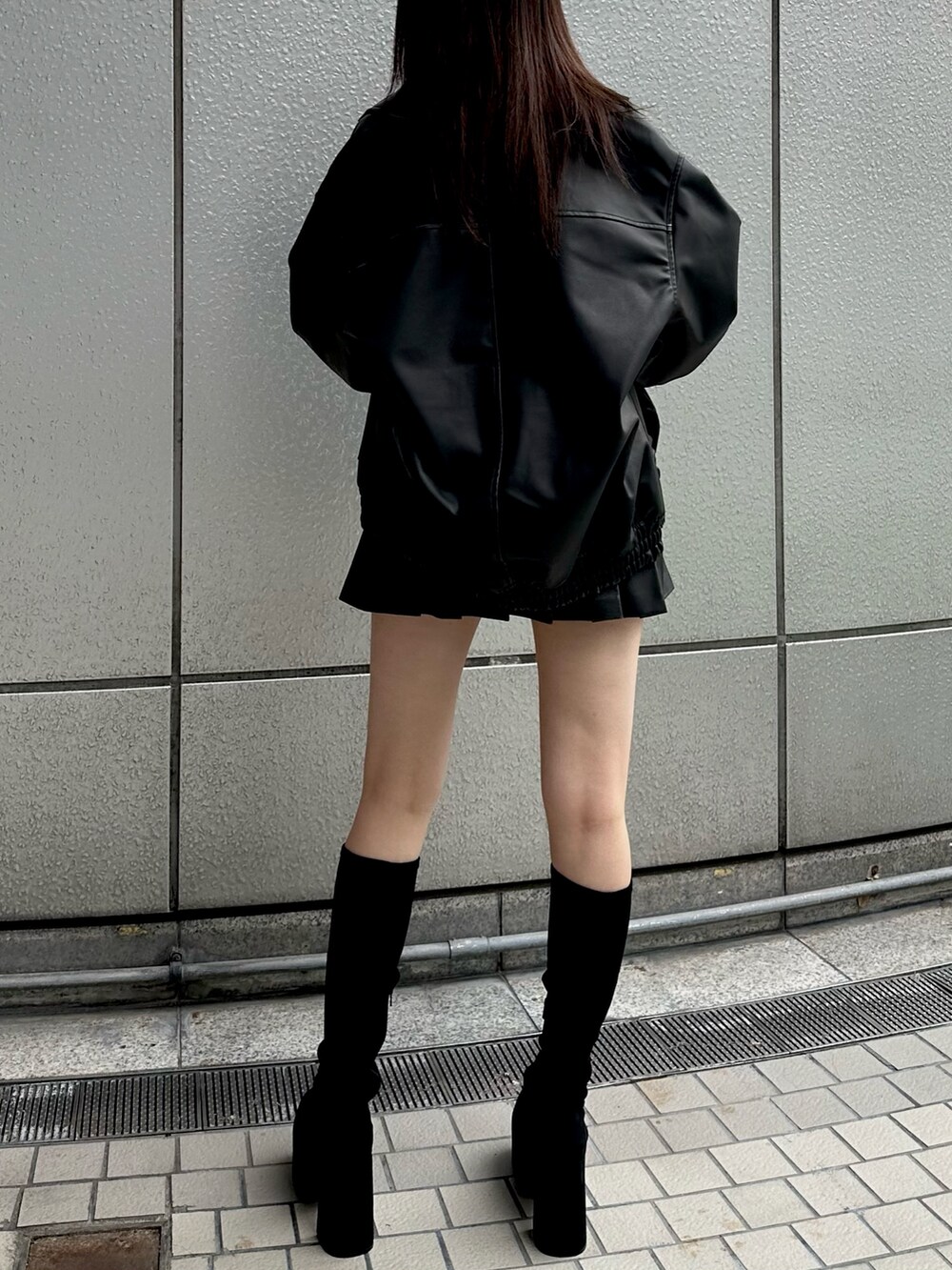 ブラック系のブルゾン、ブラック系のニット/セーター、ブラック系のスカートを着用したレディースの秋コーディネートの3枚目の写真