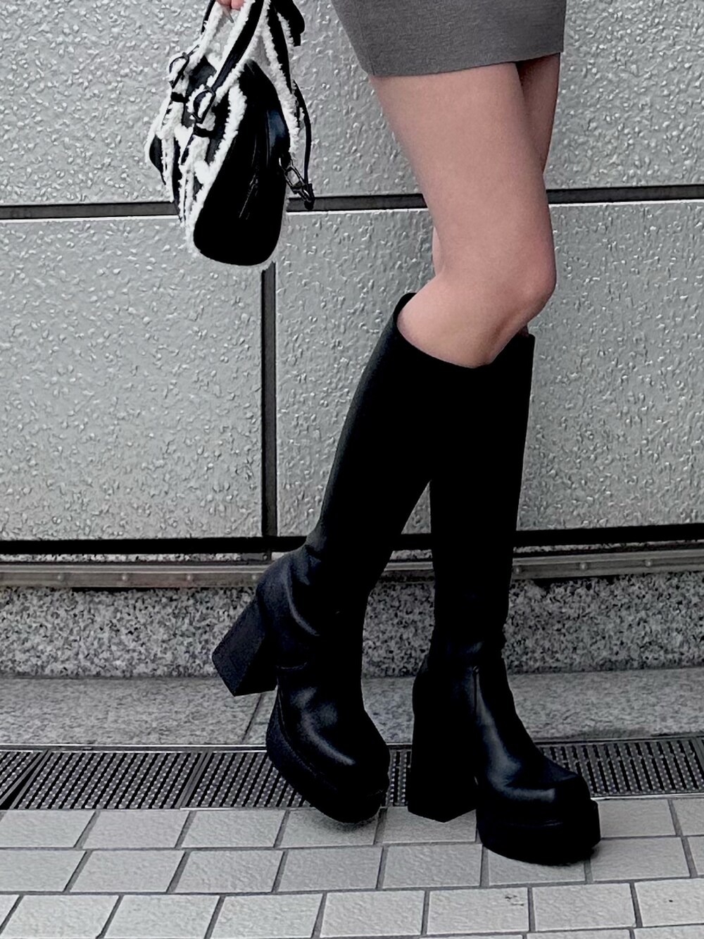 グレー系のワンピース、ブラック系のブーツを着用したレディースの秋コーディネートの4枚目の写真