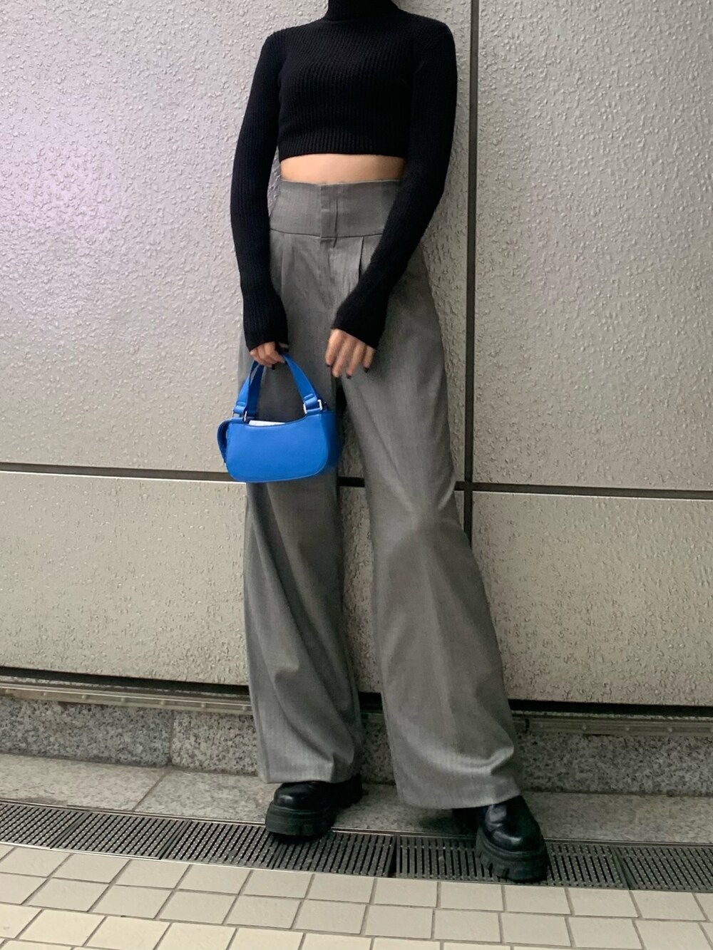 ブラック系のニット/セーター、グレー系のその他パンツ、ブルー系のハンドバッグを着用したレディースの冬コーディネートの4枚目の写真