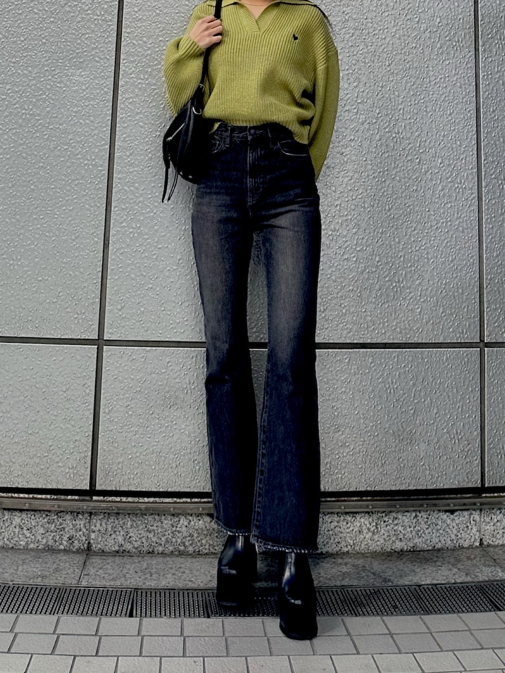 グリーン系のニット/セーター、ブラック系のデニムパンツ、ブラック系のハンドバッグを着用したレディースの冬コーディネートの2枚目の写真
