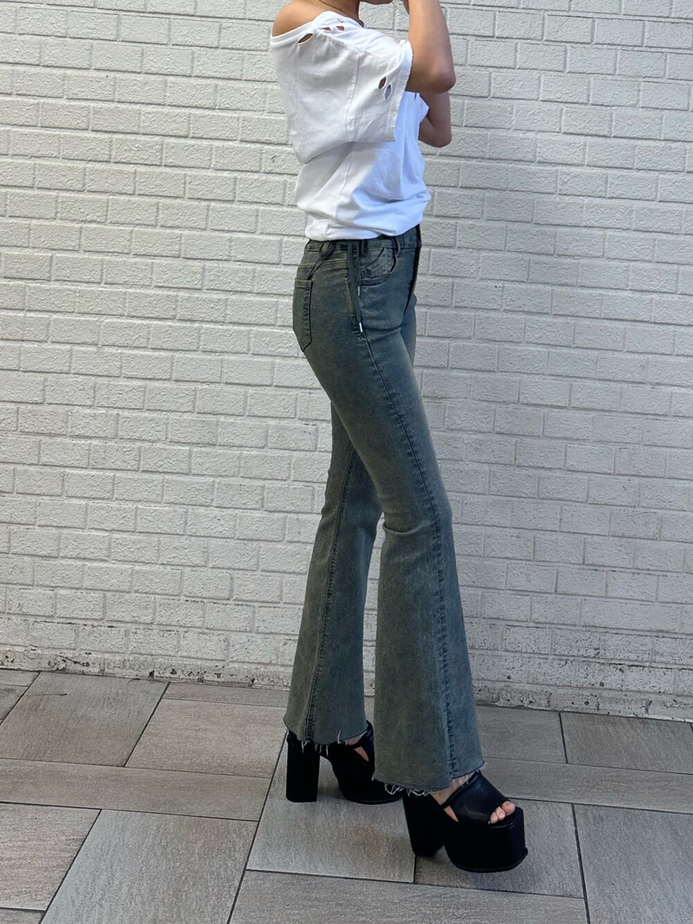 ホワイト系のTシャツ/カットソー、ブルー系のデニムパンツ、ブラック系のサンダルを着用したレディースの春コーディネートの2枚目の写真