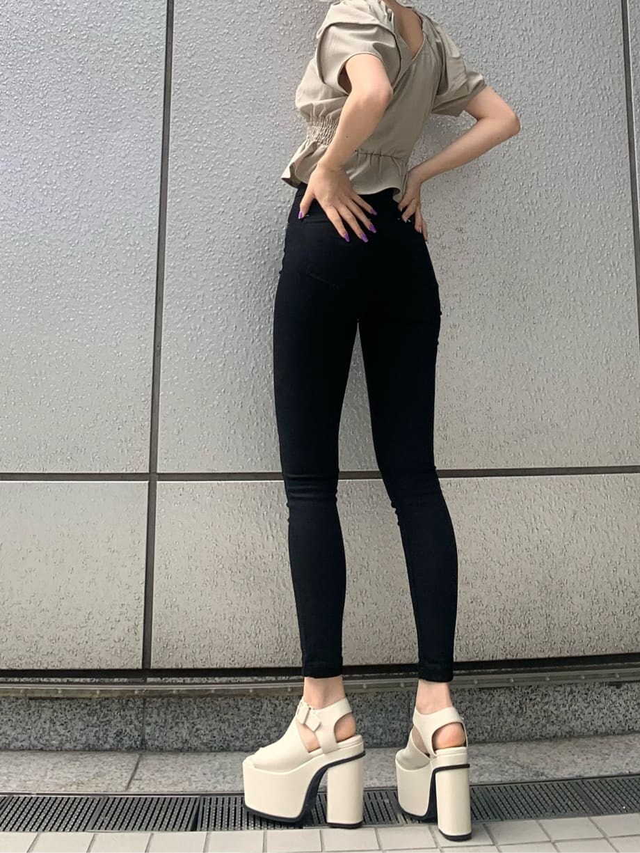 ブラック系のデニムパンツ、ホワイト系のサンダル、ベージュ系のシャツ/ブラウスを着用したレディースの春コーディネートの4枚目の写真