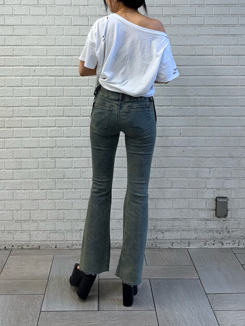 ホワイト系のTシャツ/カットソー、ブルー系のデニムパンツ、ブラック系のサンダルを着用したレディースの春コーディネートの3枚目の写真